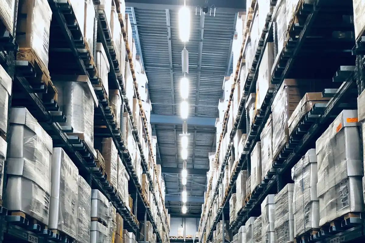 Estanterías altas de una bodega con mercadería ordenada en pasillos