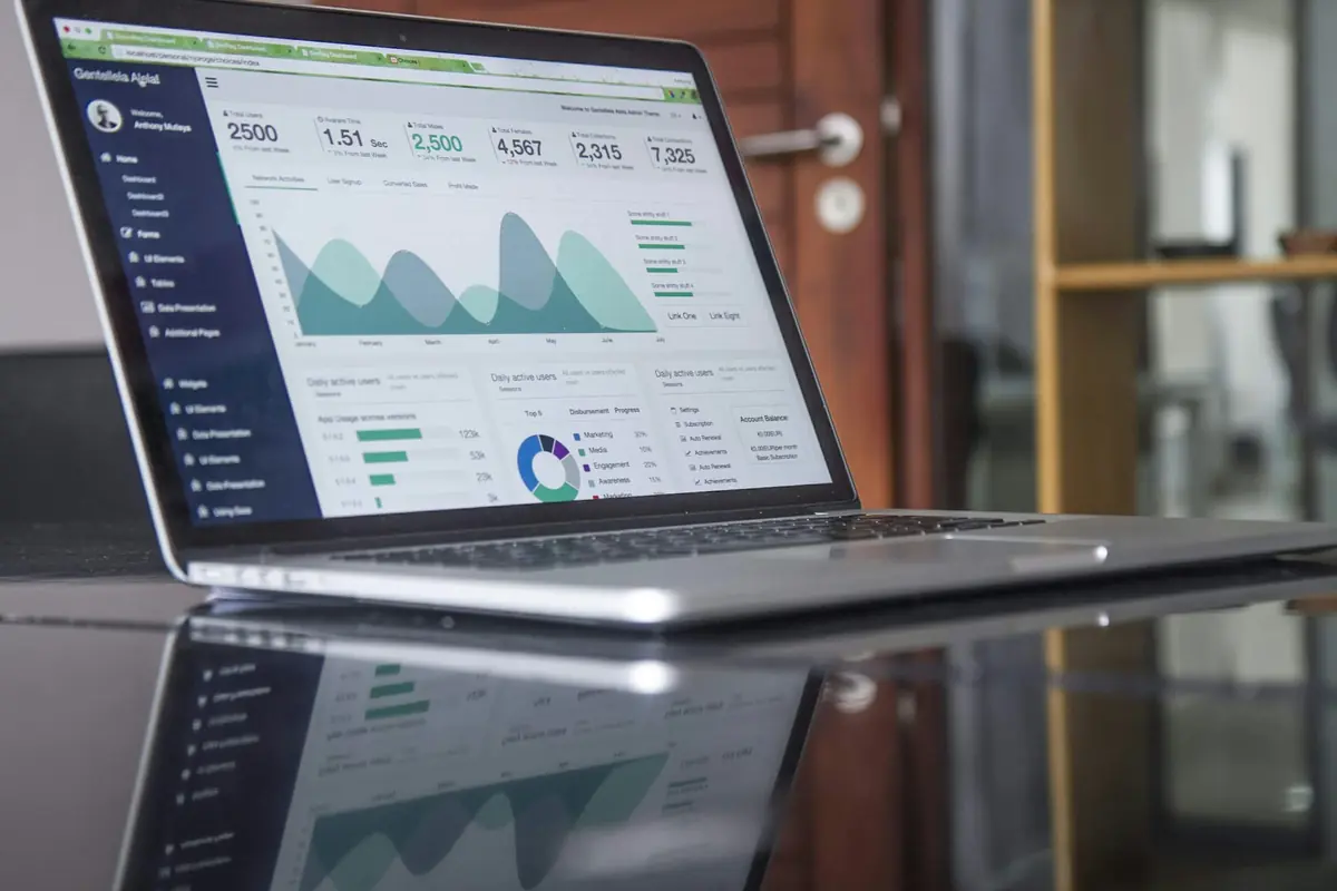 Laptop con un panel de analítica web con gráficas y cifras sobre una mesa